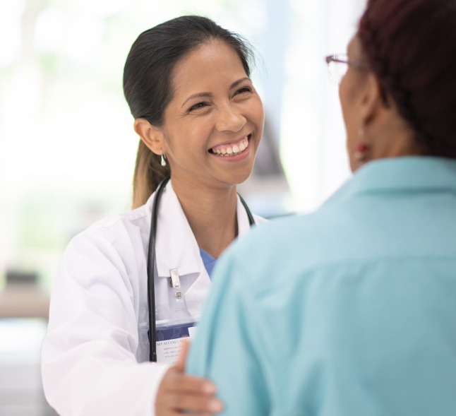 Female Doctor with woman patient, smiling and enjoying conversation